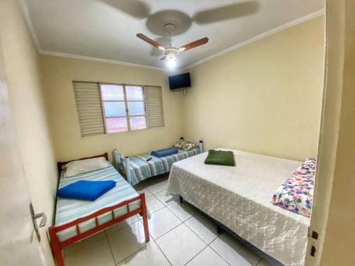 a bedroom with two beds and a ceiling fan at Casarão Hostel in Guaratinguetá
