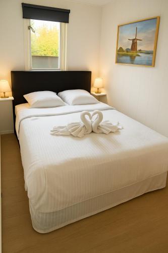 a white bed with a bow on top of it at Moonlight Nature Holiday Home in Westergeest