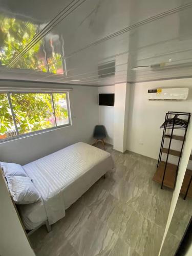 ein kleines Schlafzimmer mit einem Bett und einem Fenster in der Unterkunft Edificio Cardamomo in Neiva