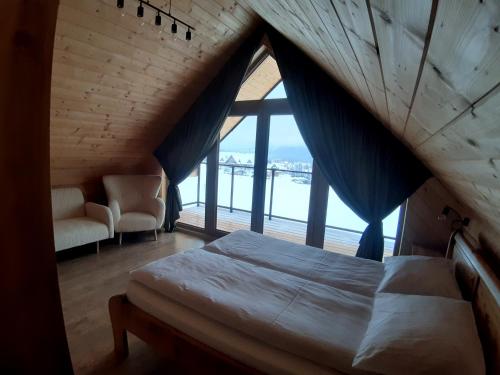 a bedroom with a bed and a large window at Koziniec ski & chill in Czarna Góra