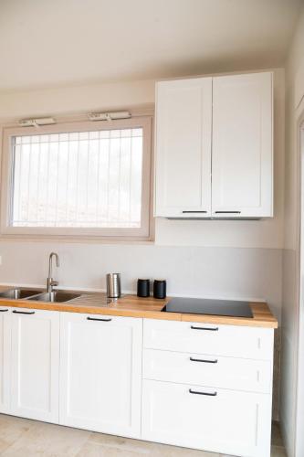 a kitchen with white cabinets and a sink at Moderno Mediterraneo in Alberobello