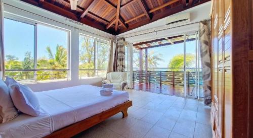 a bedroom with a bed in a room with windows at Holiblue in Blue Bay