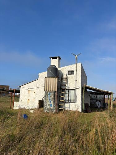 a white building in the middle of a field at Rancho Tres11 in Cabo Polonio