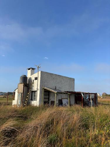 an old building in the middle of a field at Rancho Tres11 in Cabo Polonio