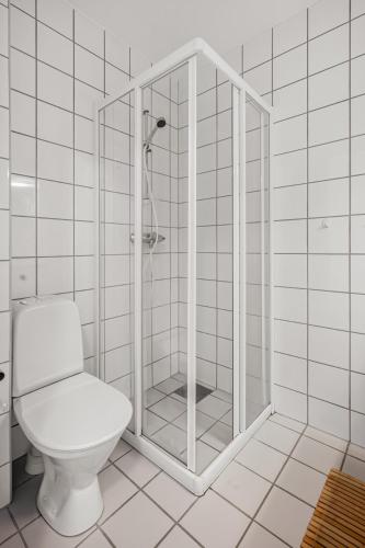 a white bathroom with a toilet and a shower at Central-Trondheim Riverside Studio-Apartment in Trondheim