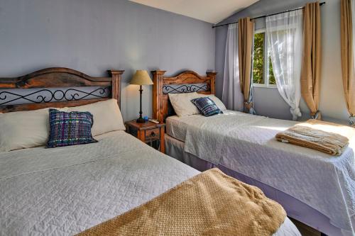 a bedroom with two beds and a window at Nico Hotel in Antigua Guatemala