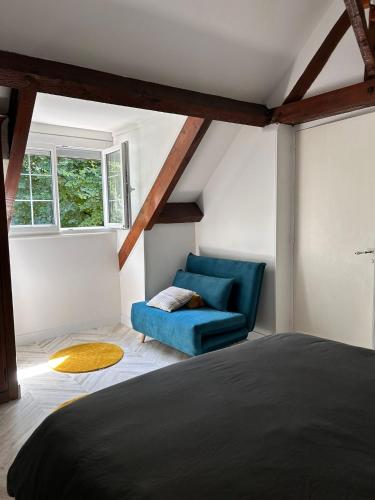 a bedroom with a blue couch and a window at Maison aux portes de Dijon à la campagne in Izier