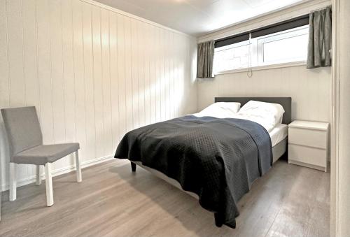a bedroom with a bed and a chair and a window at Apartment centrally located in Bud in Bud