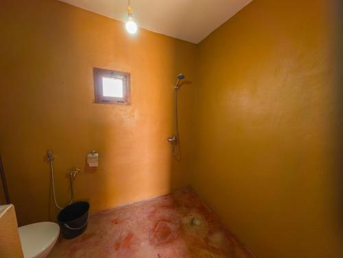 a small bathroom with a toilet and a window at Sahara Peace in Mhamid