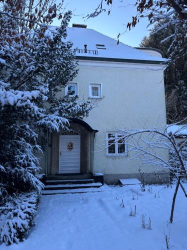 a white house with a garage in the snow at Villa Vilma Antica in Laufen