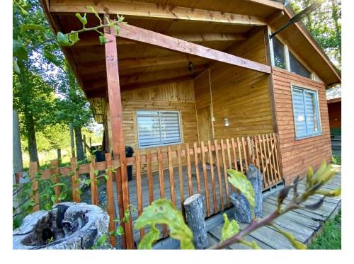 a wooden cabin with a fence in front of it at Cabañas EcoSur - Chile in Curacautín