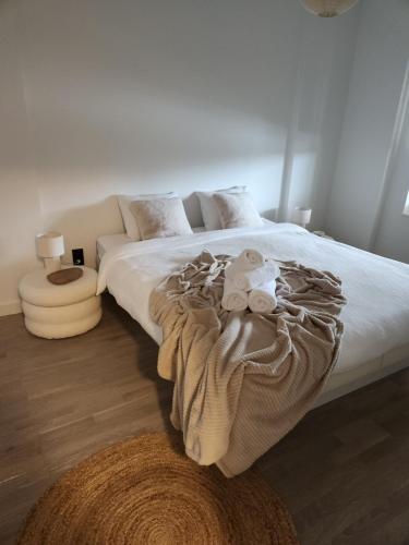 a bedroom with a large white bed with a brown blanket at Verliefd in Brustem in Sint-Truiden