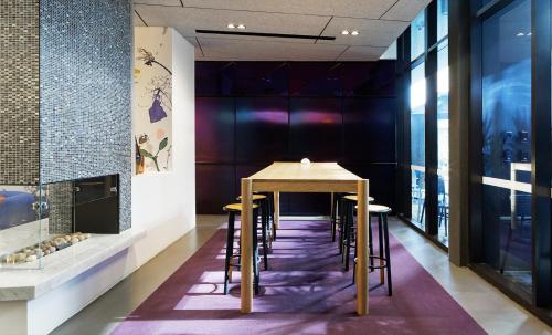 a table and chairs in a room with a fireplace at Alpha Mosaic Hotel Fortitude Valley Brisbane in Brisbane