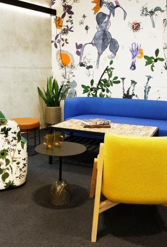a living room with a blue couch and yellow chairs at Alpha Mosaic Hotel Fortitude Valley Brisbane in Brisbane