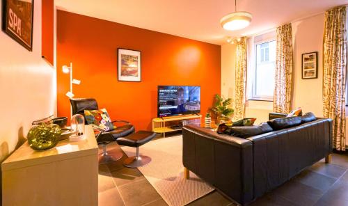 a living room with a couch and a television at Au Petit Pierrot in Spa