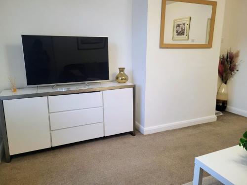 a living room with a television on a white dresser at Modern North Shields Home - Perfect for Short or Long Stays in Newcastle upon Tyne