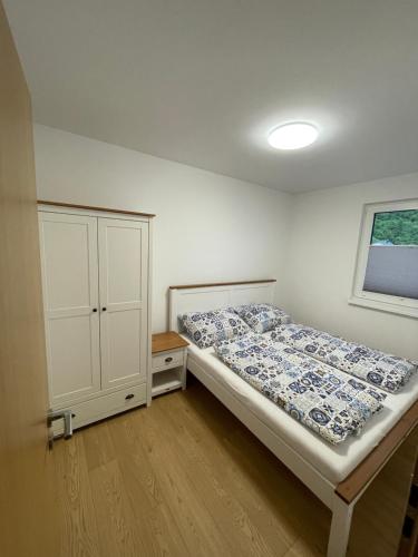 a bedroom with a bed and a cabinet and a window at Chata-Elko Habovka in Habovka