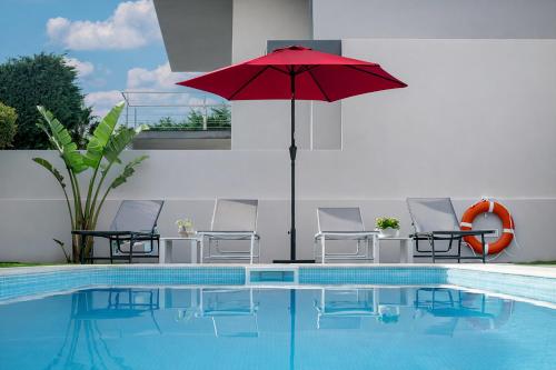 a red umbrella sitting next to a swimming pool at Sintra Dream Garden Villa near Cascais in Sintra