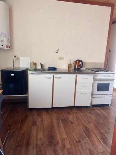 a kitchen with white cabinets and a stove at Tu Espacio en Rada in Rada Tilly