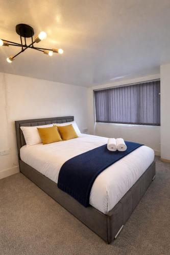 a bedroom with a large bed with two towels on it at The City Gateway Villa in Manchester