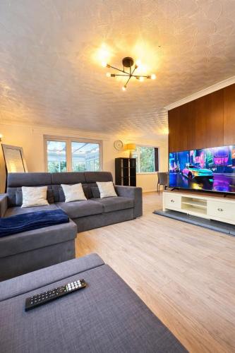 a living room with a couch and a flat screen tv at The City Gateway Villa in Manchester