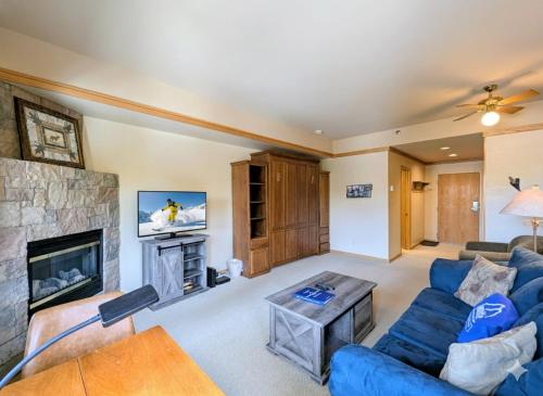 a living room with a blue couch and a fireplace at Slopeside 2773A by SummitCove Lodging in Keystone