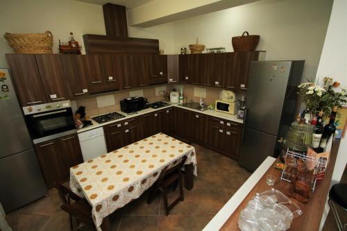 a kitchen with wooden cabinets and a table in it at Pensiunea Eden in Băile Olăneşti
