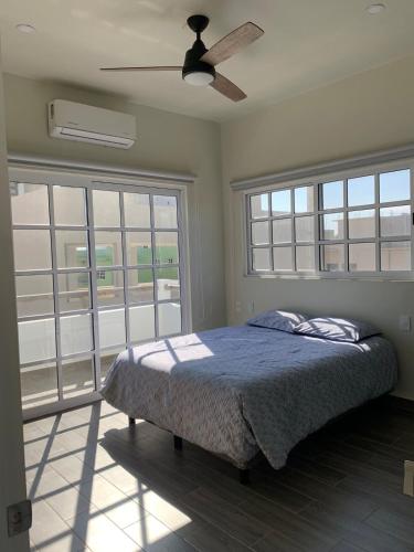a bedroom with a bed and a ceiling fan at Brisa Marina in Playa Agua Blanca