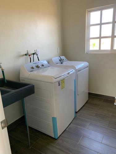 a laundry room with a washer and a sink at Brisa Marina in Playa Agua Blanca