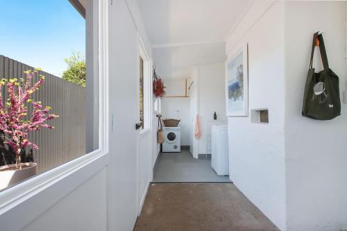 a hallway of a house with white walls and a window at The Gums, Beechworth in Beechworth