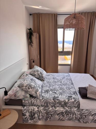 a bed in a bedroom with a view of the ocean at Rosalia28 in Antigua