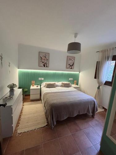 a bedroom with a bed and a green wall at El Castaño in Guisando