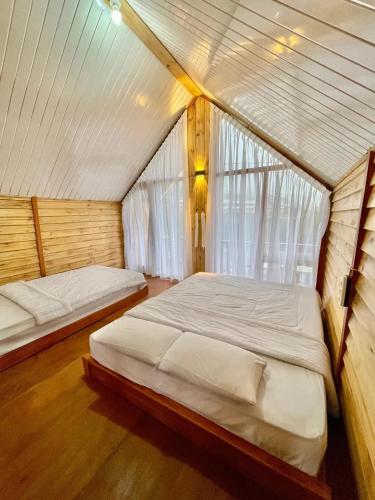 a bedroom with two beds in a tent at Miarzafa Cabin House DIENG in Kejajar
