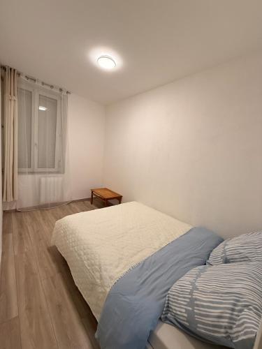 a bedroom with a bed and a window at 4-person apartment in Joeuf