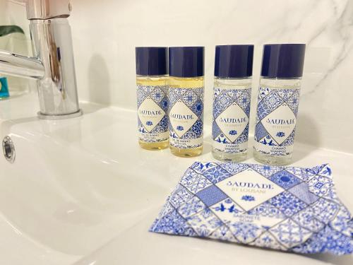 three blue and white bottles sitting on top of a sink at Casa do Pelourinho in Arcos de Valdevez