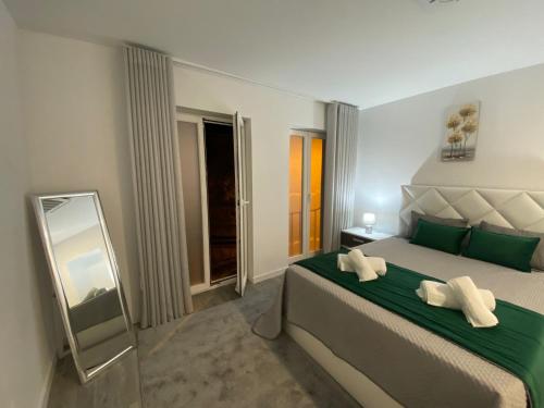 a bedroom with a large bed with green pillows at Casa do Pelourinho in Arcos de Valdevez