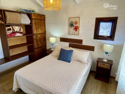 a bedroom with a bed with a blue pillow on it at OHANA in Punta Del Diablo