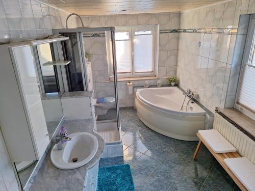 a bathroom with a tub and a toilet and a sink at Ferienwohnung Silchmüller in Zella-Mehlis