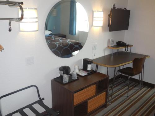 a room with a mirror and a desk and a bed at Super 8 by Wyndham Sault Ste. Marie in Sault Ste. Marie