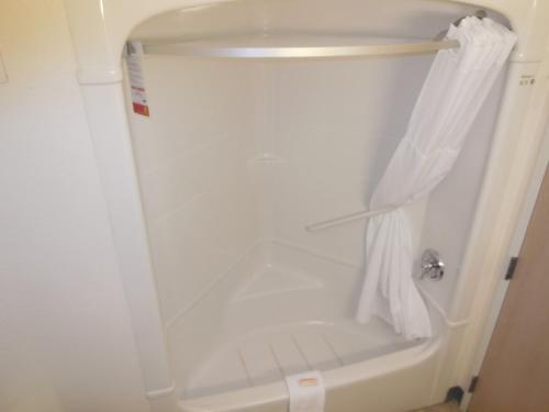 a bathroom with a shower with a white curtain at Super 8 by Wyndham Sault Ste. Marie in Sault Ste. Marie