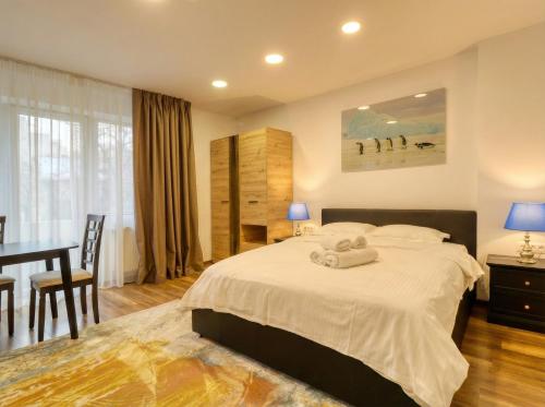 a bedroom with a bed and a table and a desk at 2 Hidden Gems - all U need - by Uni88 in Bucharest