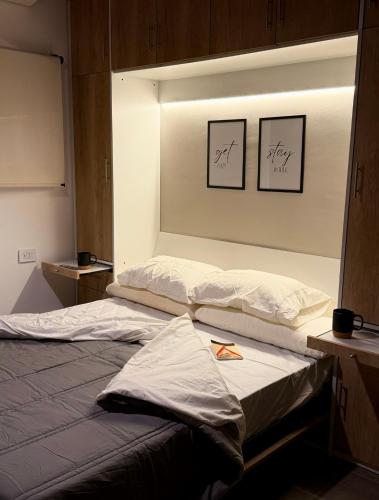 two beds in a room with two pictures on the wall at Espacio Nidra - Tu descanso a pasos del Aeropuerto in Ezeiza