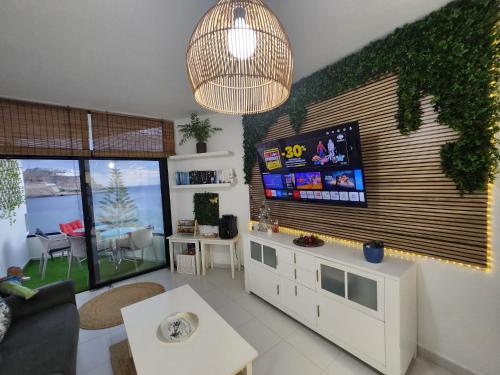 a living room with a flat screen tv on a wall at Ocean Luxury Apartment in Mogán