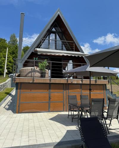 a building with chairs and an umbrella on a patio at Villa Monteverde Goč in Stanišinci