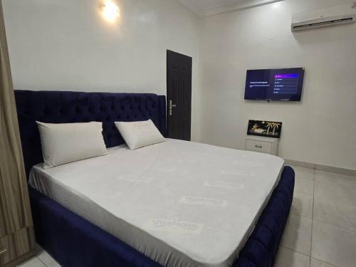 a bedroom with a large bed with a blue headboard at Pavilion Luxury 4bedroom duplex in Mama