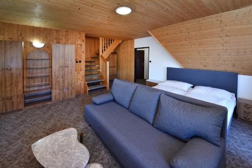 a living room with a couch and a bed at Penzión Valaška in Starý Smokovec