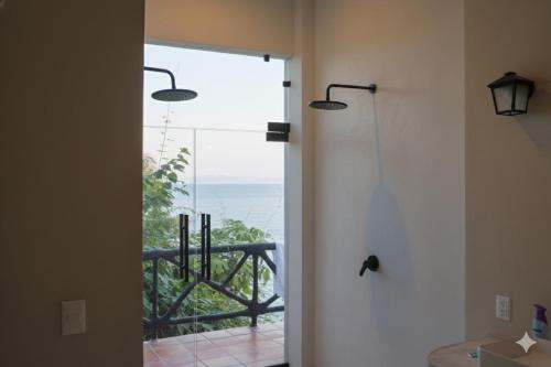 a bathroom with a shower with a view of the ocean at Casa Azul, Oceanfront Estate with Rooftop Deck in Yelapa