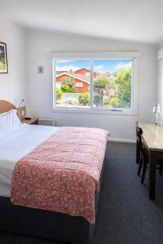 a bedroom with a bed and a large window at The Dannebrog Lodge in Devonport