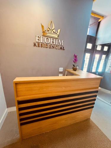 a reception desk with a sign on the wall at Elohim Residencial in Rio de Janeiro
