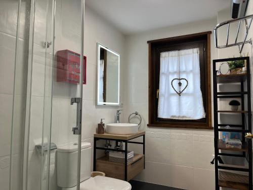 a bathroom with a toilet and a window with a heart drawn on a curtain at Les 3 Valls in Llavorsí